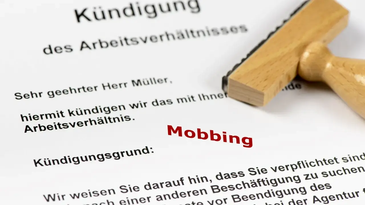 Kündigungsschreiben mit dem Grund "Mobbing". Ein Stempel liegt daneben. Dies kann zu einer Krankschreibung führen.