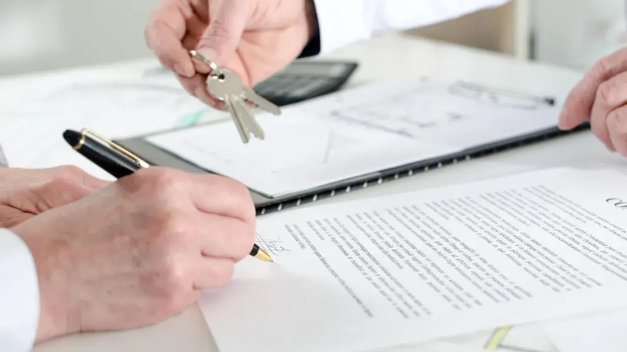 Schlüsselübergabe und Unterschrift eines Untermieter Mietvertrags.