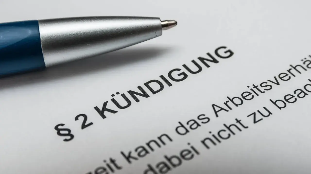 Stift auf Kündigungsschreiben. Nach 10 Jahren im Unternehmen steht die Abfindung im Raum.