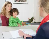 Mutter mit Kind im Gespräch mit einer Person vom Jugendamt. Beistandschaft Jugendamt bis zu welchem Alter? Hier wird über die Unterstützung gesprochen.