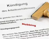 Kündigungsschreiben mit dem Grund "Mobbing". Ein Stempel liegt daneben. Dies kann zu einer Krankschreibung führen.