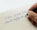 Hand schreibt mit Füllfederhalter auf Papier: "Mein letzter Wille. Hiermit verfüge ich..." – Vorsicht vor Formfehlern bei Testamenten!