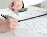 Schlüsselübergabe und Unterschrift eines Untermieter Mietvertrags.