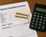 Gehaltsabrechnung mit Notiz "Abfindung berechnen" und Taschenrechner. Wichtig für die Abfindung im Kleinbetrieb.
