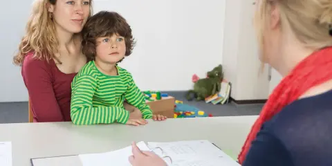 Mutter mit Kind im Gespräch mit einer Person vom Jugendamt. Beistandschaft Jugendamt bis zu welchem Alter? Hier wird über die Unterstützung gesprochen.