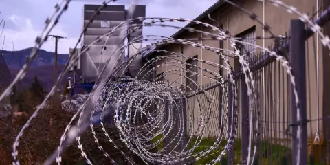 Stacheldraht vor einem Gebäude. Ein Haftbefehl erlassen wegen Unterhaltspflichtverletzung könnte hier eine Rolle spielen.