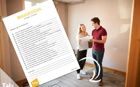 Ein Paar prüft eine Checkliste für die Wohnungsbesichtigung in einer leeren Wohnung.