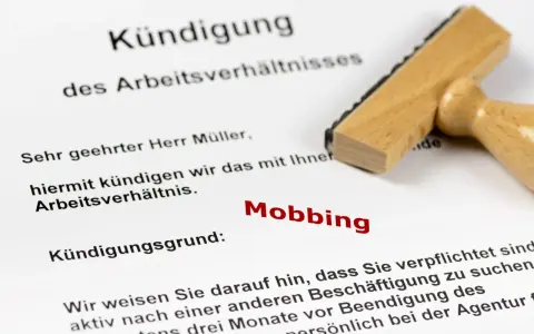 Kündigungsschreiben mit dem Grund "Mobbing". Ein Stempel liegt daneben. Dies kann zu einer Krankschreibung führen.