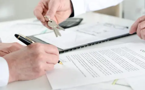 Schlüsselübergabe und Unterschrift eines Untermieter Mietvertrags.