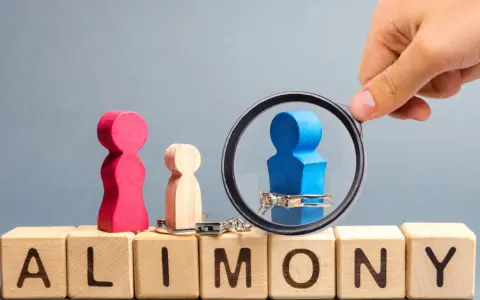 Holzfiguren und Handschellen auf Würfeln mit "ALIMONY". Ein blauer Mann unter Lupe, der Unterhaltsschulden und Privatinsolvenz symbolisiert, die das Jugendamt betreffen.