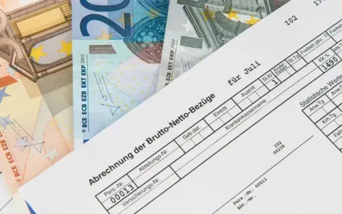 Lohnabrechnung für Juli mit Euro-Scheinen. Der niedrige Lohn lässt vermuten, dass der Arbeitgeber zu wenig zahlt.