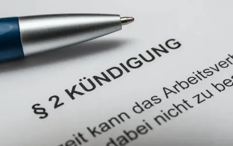 Stift auf Kündigungsschreiben. Nach 10 Jahren im Unternehmen steht die Abfindung im Raum.