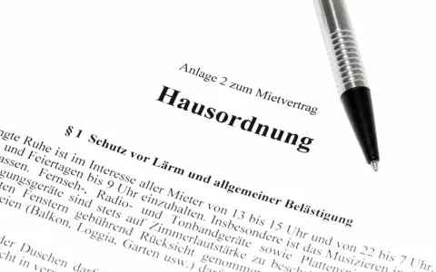 Hausordnung für ein Mehrfamilienhaus, Anlage zum Mietvertrag. Ein Stift liegt auf dem Dokument.