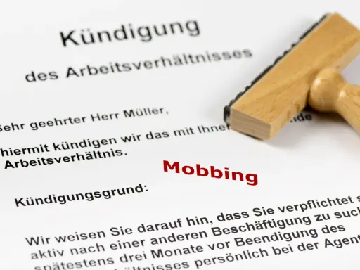 Kündigungsschreiben mit dem Grund "Mobbing". Ein Stempel liegt daneben. Dies kann zu einer Krankschreibung führen.