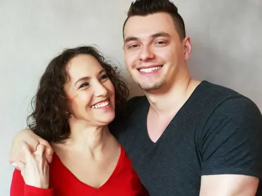 Glückliche Mutter und ihr erwachsener Sohn, der noch zu Hause wohnt. Sie lachen und umarmen sich.