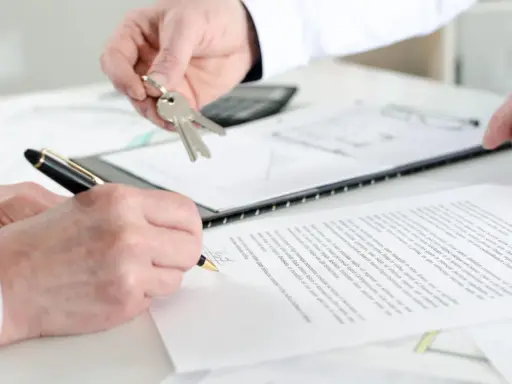 Schlüsselübergabe und Unterschrift eines Untermieter Mietvertrags.