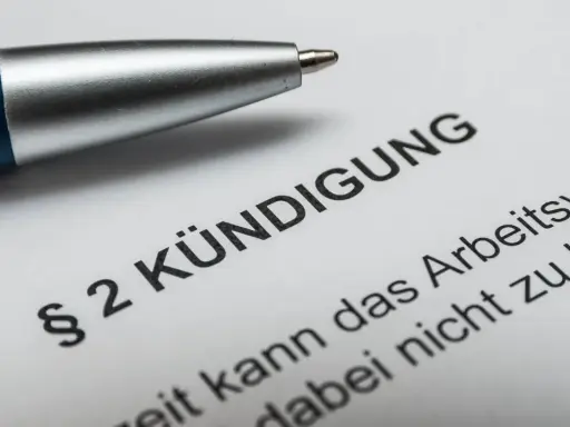 Stift auf Kündigungsschreiben. Nach 10 Jahren im Unternehmen steht die Abfindung im Raum.