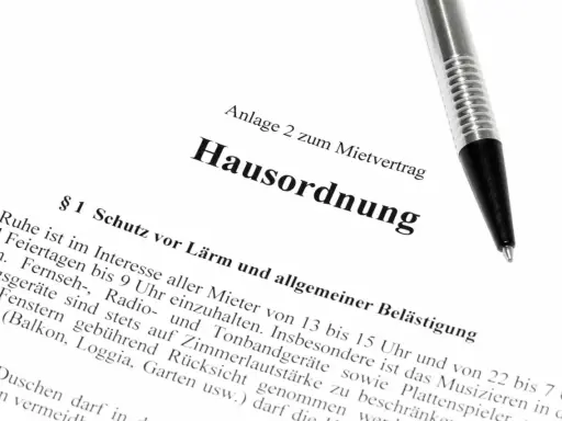 Hausordnung für ein Mehrfamilienhaus, Anlage zum Mietvertrag. Ein Stift liegt auf dem Dokument.