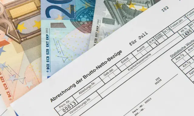 Lohnabrechnung für Juli mit Euro-Scheinen. Der niedrige Lohn lässt vermuten, dass der Arbeitgeber zu wenig zahlt.