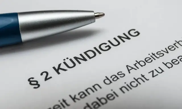 Stift auf Kündigungsschreiben. Nach 10 Jahren im Unternehmen steht die Abfindung im Raum.