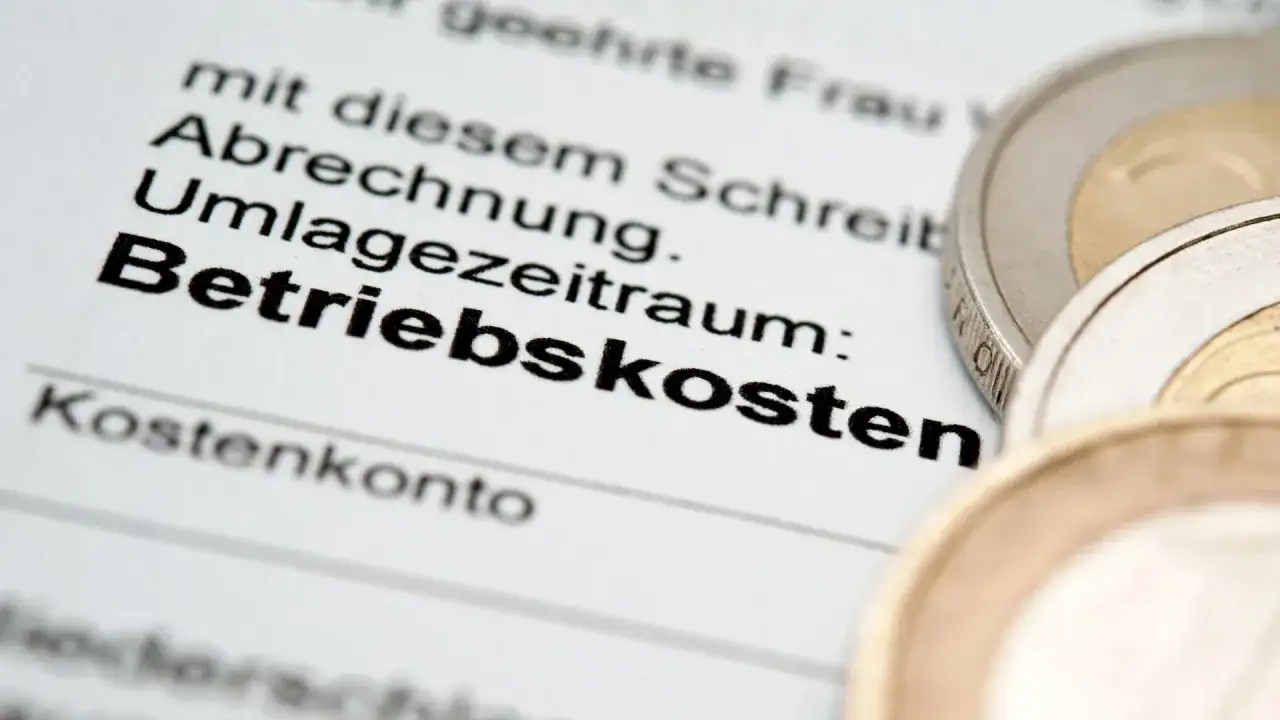 Abrechnung der Betriebskosten. Die Kaution wird einbehalten bis zur Nebenkostenabrechnung. Münzen liegen auf dem Dokument.
