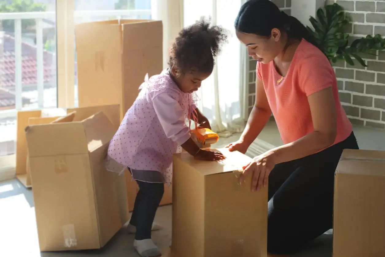 Mutter und Kind packen Kartons für den Umzug. Gemeinsames Sorgerecht bedeutet auch, gemeinsam neue Wege zu gehen.
