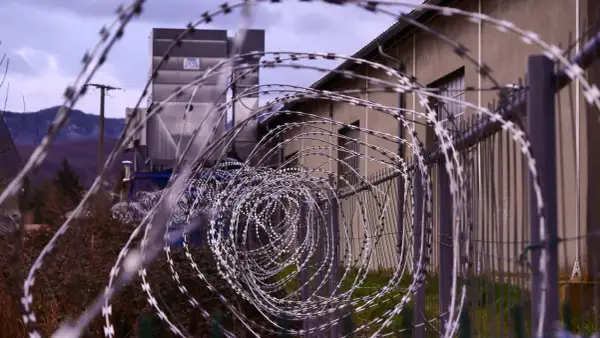 Stacheldraht vor einem Gebäude. Ein Haftbefehl erlassen wegen Unterhaltspflichtverletzung könnte hier eine Rolle spielen.